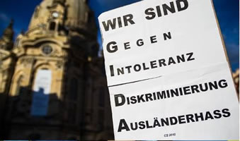 Transpi-Vorlage "WIR SIND G.. I.. D.. A.." im Einsatz - vor der Kulisse der Dresdner Frauenkirche im Abendsonnenlicht bei einer Demo des Bündnisses "NOPE"