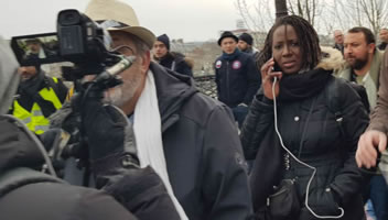 Foto von Bernard Schmid: Ein paar führende Exponenten der Bewegung - Philippe Pascot (links, Schriftsteller, durch die Kamera reflektiert) und Priscillia Ludosky (mit Ohrstöpsel) bei der Demo in Paris am 5.1.19