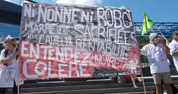 Foto von Bernd Landsiedel vom 2.7.2019 in Paris: Transparent Beschäftigter der Notaufnahmen: "Weder Nonnen noch Roboter. Wir haben es satt, auf dem Altar der Rentabilität geopfert zu werden. Hört unsere Wut"