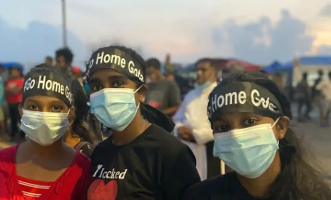 Drei Aktivistinnen mit Gota go Home Stirnband vor Protesten