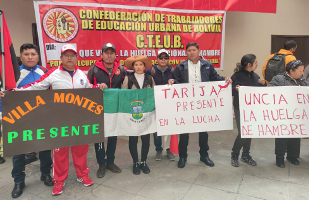 Bolivien: Lehrkräfte halten Schilder vor sich mit den Orten aus denen sie kommen und den Hungerstreik unterstützen