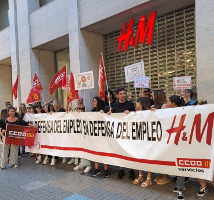 Spanien: Streikende Kolleg*innen vor einer H&M Zentrale mit Banner