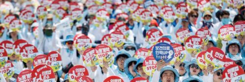 Südkorea: Tausende Pfleger*innen in weiß und mit blauen Mützen und roten Schildern demonstrieren