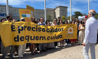 Streikende Ärzt*innen in Portugal mit gelben Banner - deutsch übersetzt: "Wir müssen uns um die kümmern, die sich kümmern"