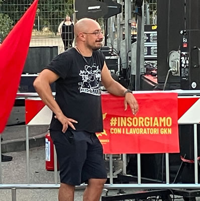 Fest zu 2 Jahren des Fabrikkollektivs ex-GKN: Gewerkschafter Dario Salvetti schaut sich das Bühnenprogramm an (Foto: Kathy Ziegler)